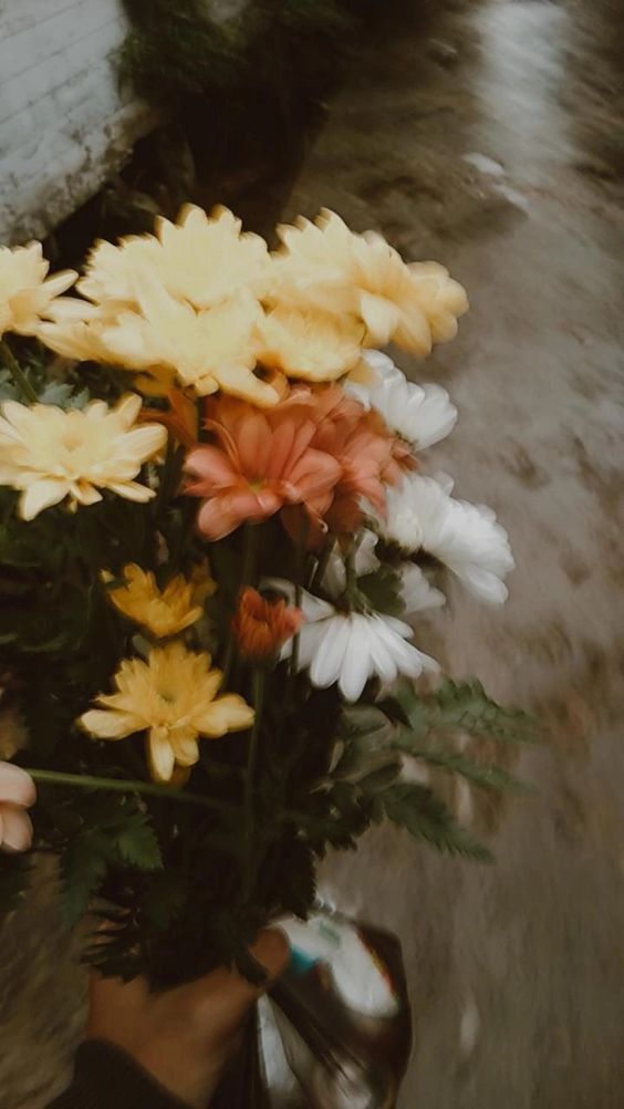 a person holding a bouquet of flowers in their hand