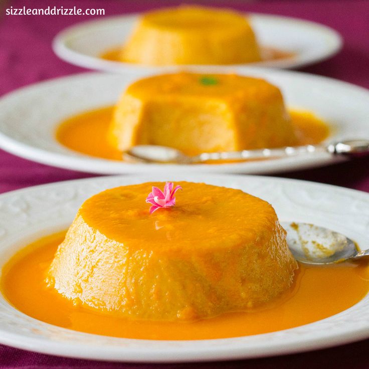 two white plates topped with cakes covered in orange sauce