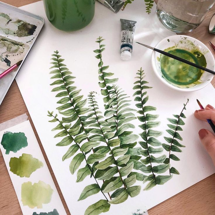 someone is painting leaves on paper with watercolors