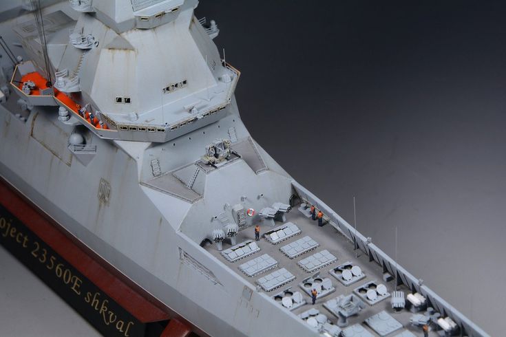 a model battleship is shown on a gray surface with red trimmings and black lettering