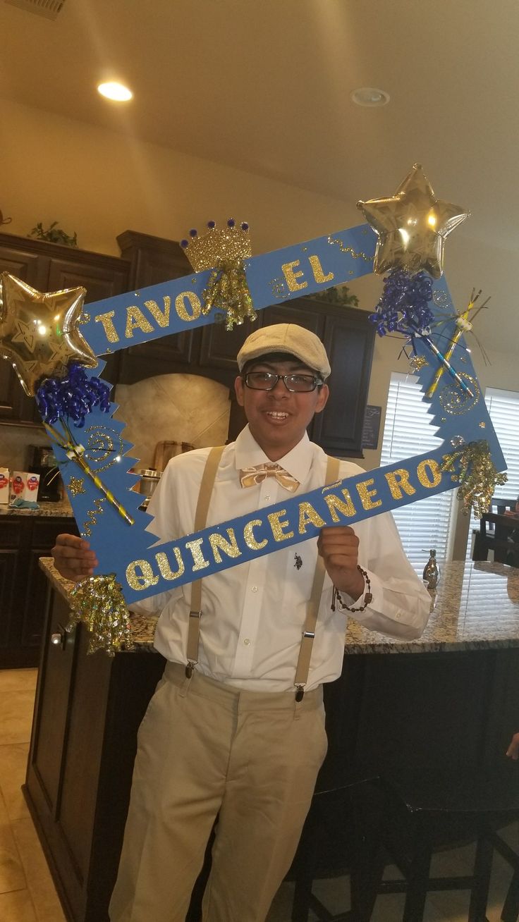 a man holding up a sign that says tavo el quinicecamentoo