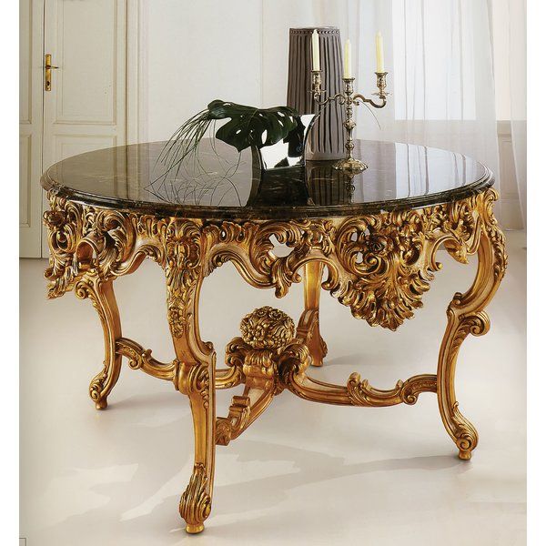 an ornately decorated coffee table with candles and a vase on it's side