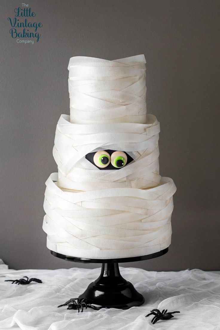 a three tiered cake decorated with white icing and fake eyes