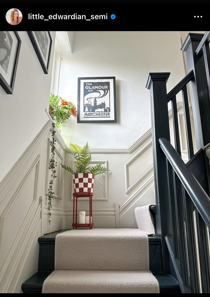 a staircase with pictures on the wall above it