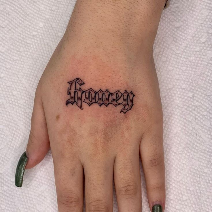 a person's hand with a tattoo on it that says honey in cursive font