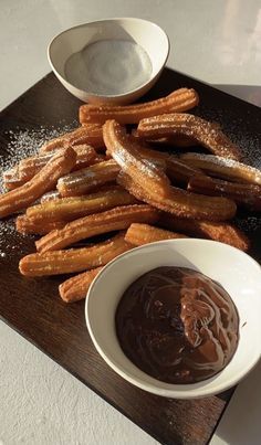 churros and dipping sauce on a wooden tray