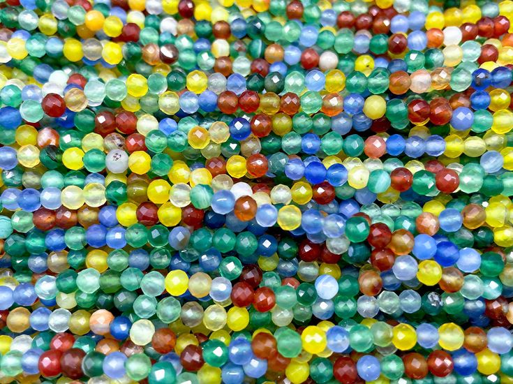 multicolored beads are scattered together on the ground in this close up shot,