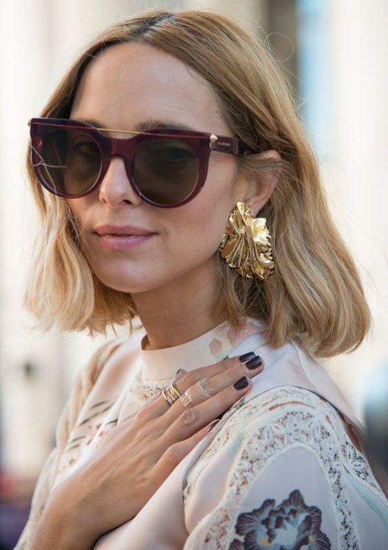 a woman wearing black sunglasses and a white blouse