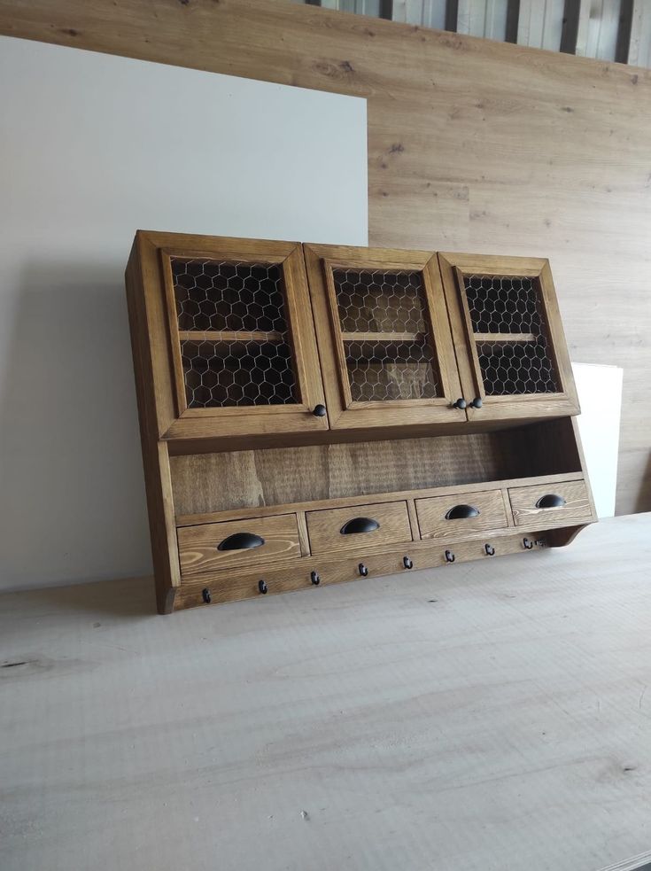 a wooden cabinet with drawers and knobs on the bottom is sitting on top of a table