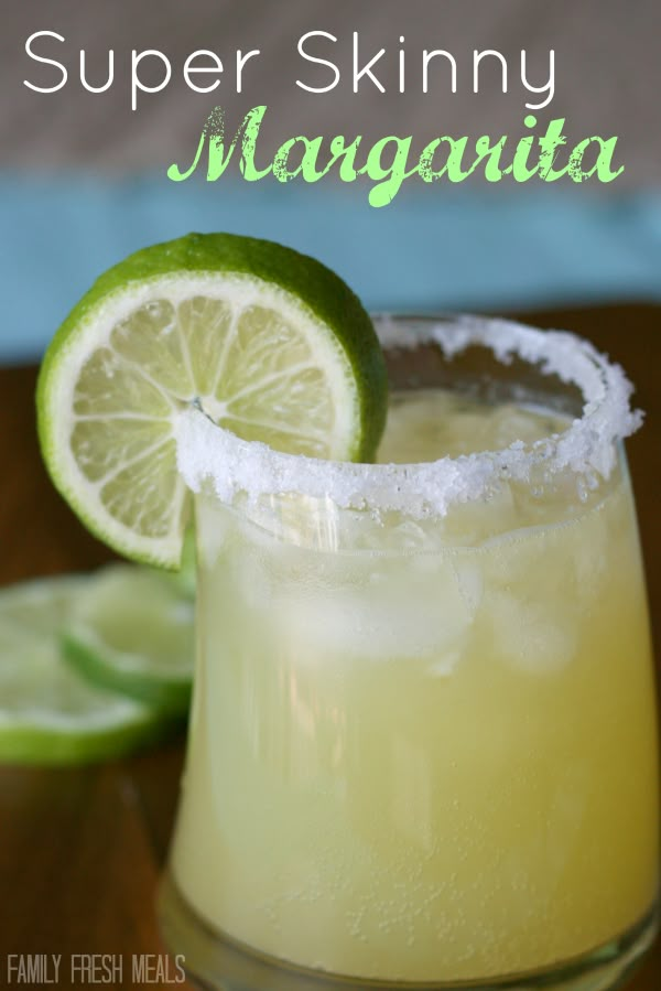 a close up of a drink in a glass with limes and sugar on the rim