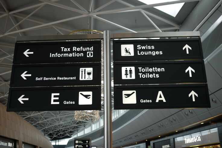 there are many signs in the airport that point to different destinations and points of interest