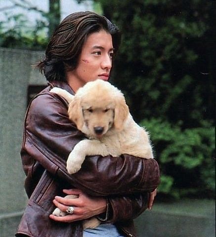 a woman holding a puppy in her arms