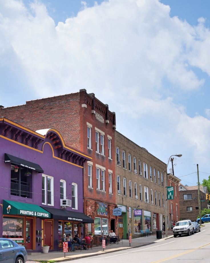 a row of buildings with cars parked on the street