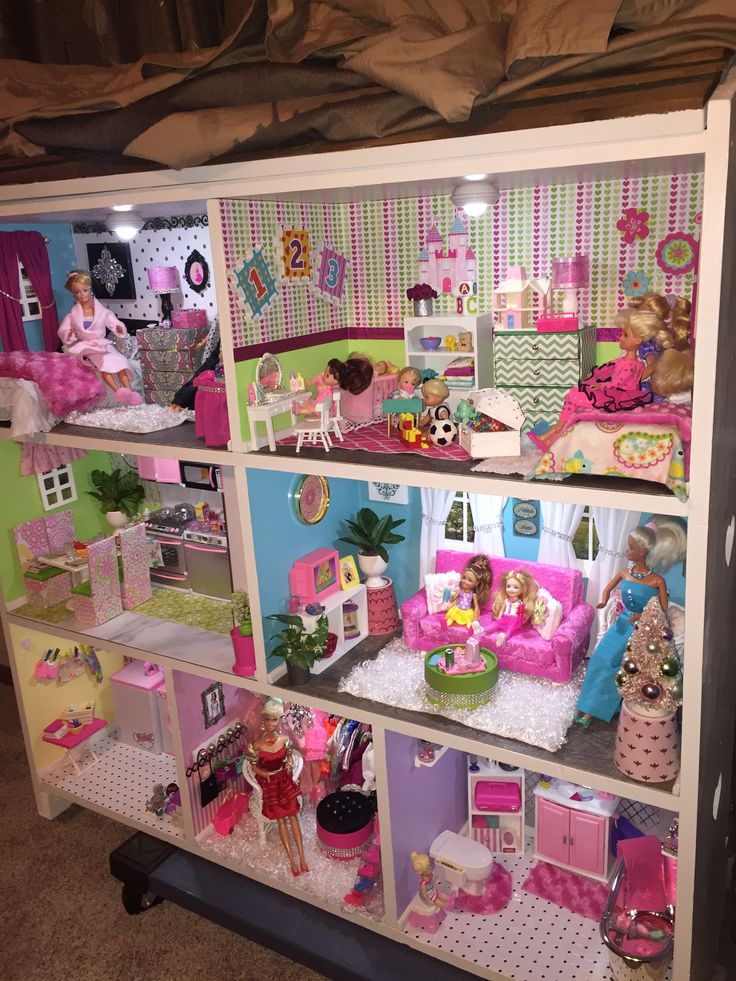 a doll house with lots of furniture and dolls in it's display case on the floor