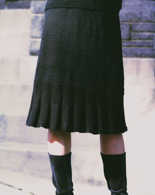 a woman wearing black boots and a skirt