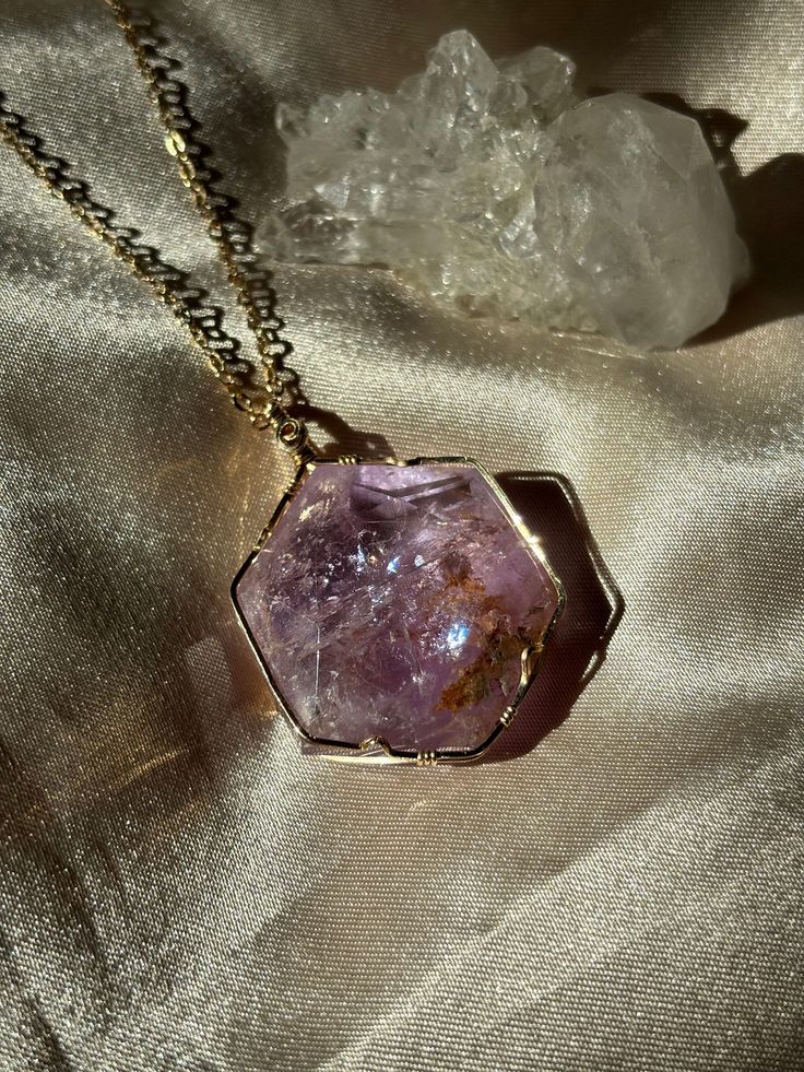 Amethyst is believed to have healing properties that protect the bearer against negative energies. Some believe that the stone's calming properties produce soothing dreams by making us more in tune with the divine. The stone also brings clarity and peacefulness to the waking mind, as they help the mind flow freely in both the mental and metaphysical dimensions. Mystical Amethyst Gemstone Crystal Necklace, Mystical Amethyst Necklace For Gift, Mystical Healing Birthstone Jewelry, Lavender Gemstone Crystal Necklace For Healing, Mystical Amethyst Crystal Necklace Gift, Spiritual Hexagon Gemstone Jewelry, Holistic Amethyst Gemstone Jewelry, Healing Lavender Gemstone Crystal Necklaces, Healing Lavender Gemstone Crystal Necklace