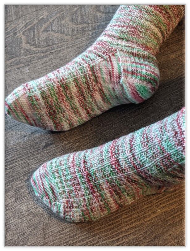 two pairs of socks sitting on top of a wooden floor