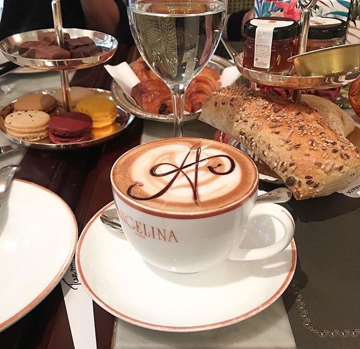 there is a cup of coffee on the table with bread and pastries around it