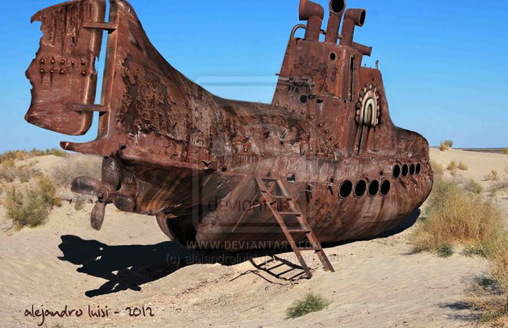 an old rusted airplane sitting in the middle of a desert area with no people around it