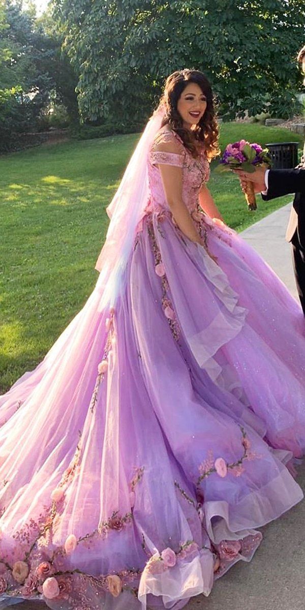 a man in a tuxedo standing next to a woman in a purple dress