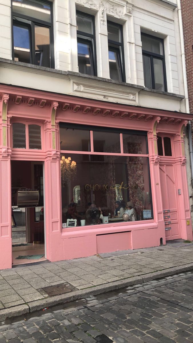 a pink store front with lots of windows