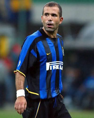 a male soccer player in a blue and black uniform is on the field during a game