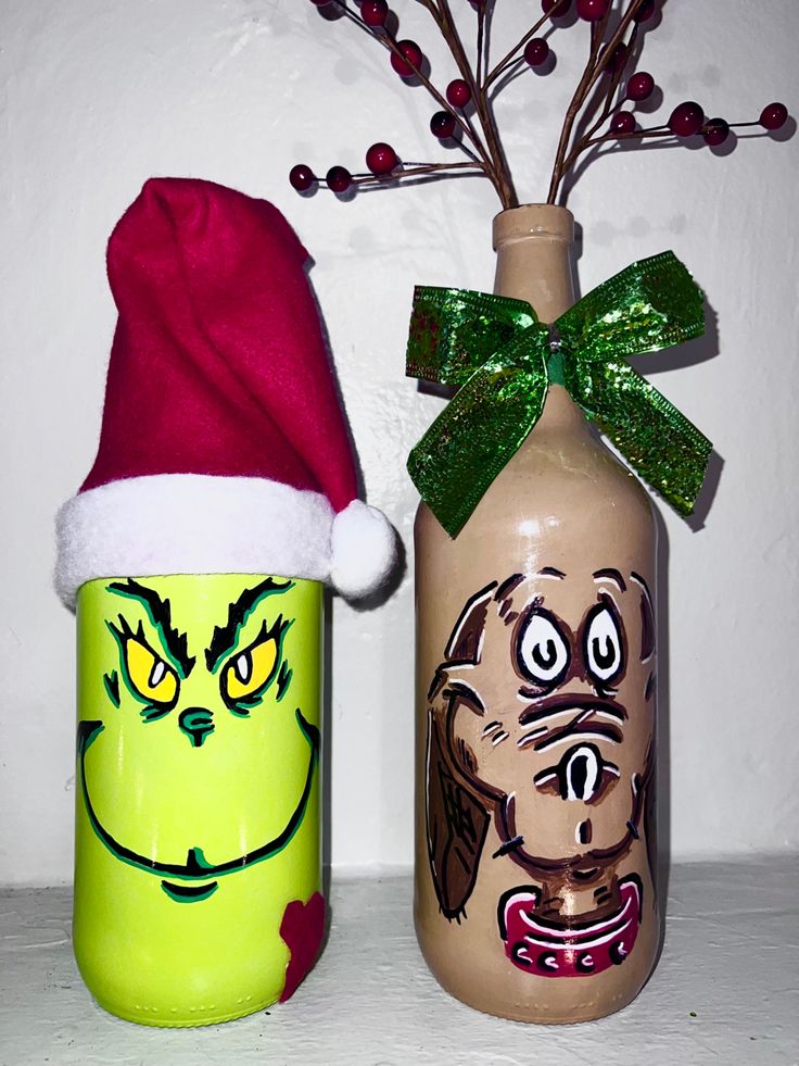 two decorated christmas jars sitting next to each other on a shelf with one wearing a santa hat