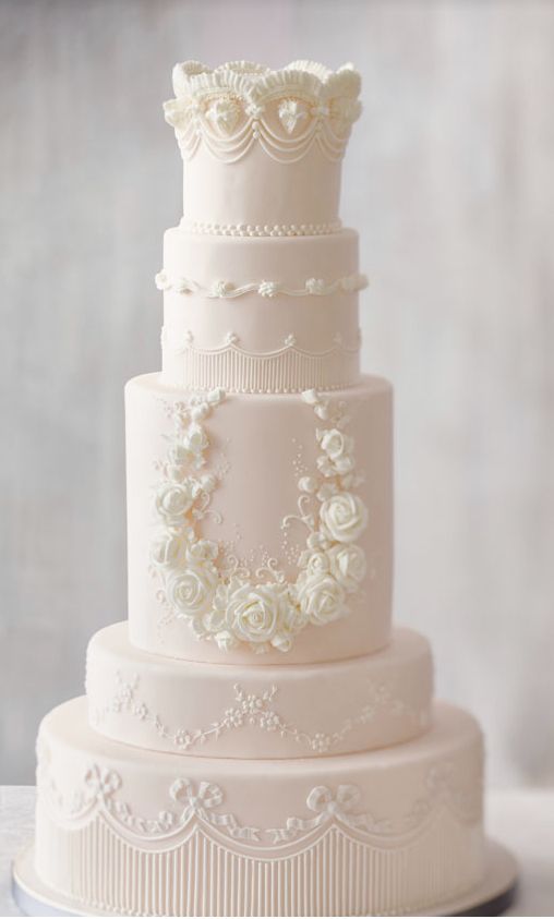 a three tiered wedding cake with white flowers