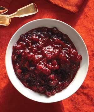 a white bowl filled with cranberry sauce on top of a red cloth