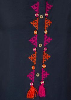 an orange and pink tasseled necklace with buttons on it's end, hanging from a black shirt