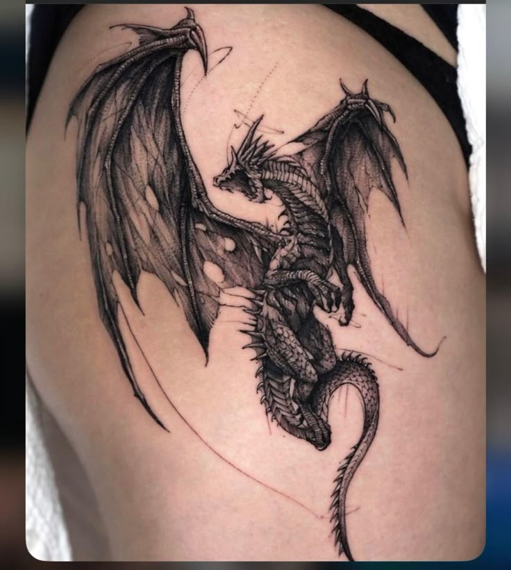 a black dragon tattoo on the side of a woman's thigh