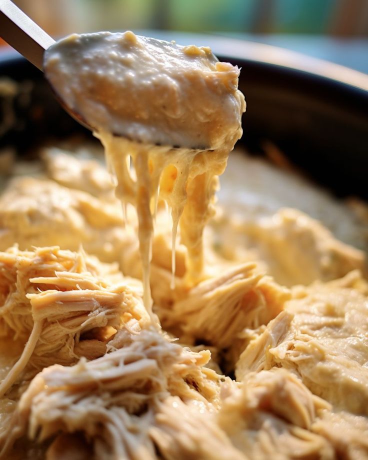 a spoon is lifting some food out of the pan with it's meat and cheese mixture