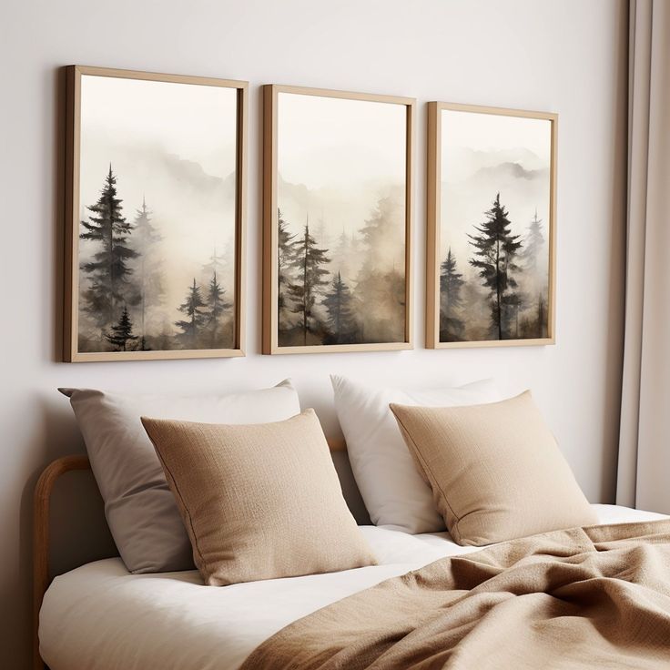 three paintings hanging on the wall above a bed in a room with pillows and blankets