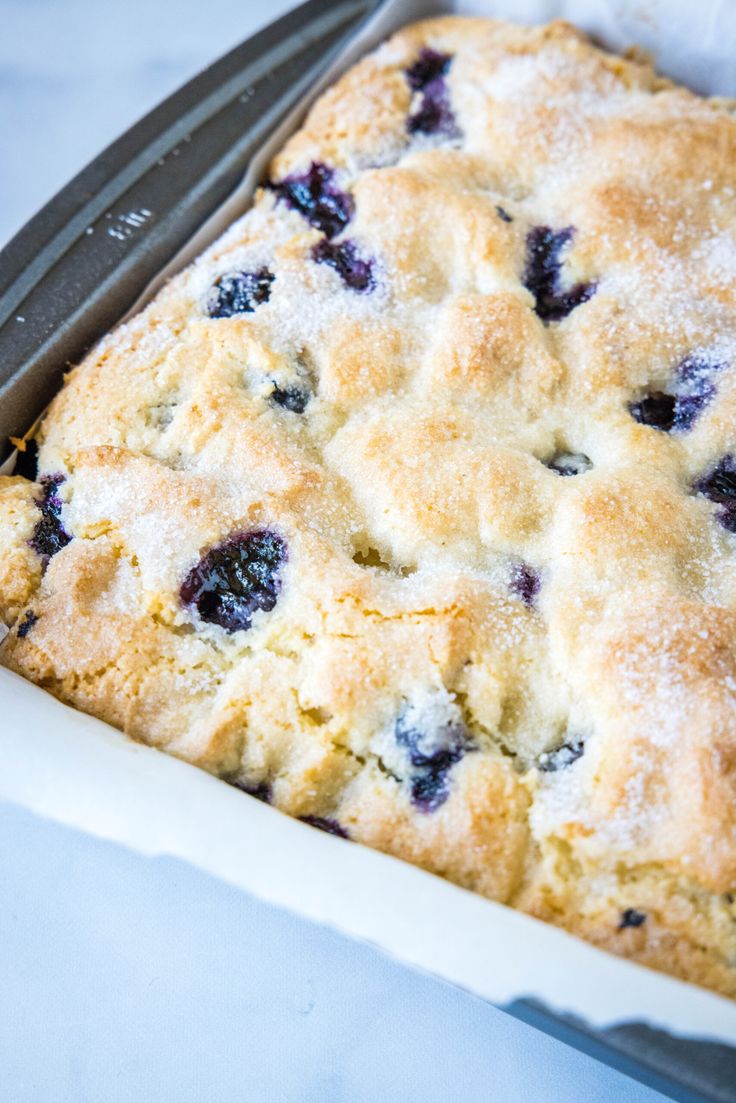 a blueberry cobbler in a pan with a knife