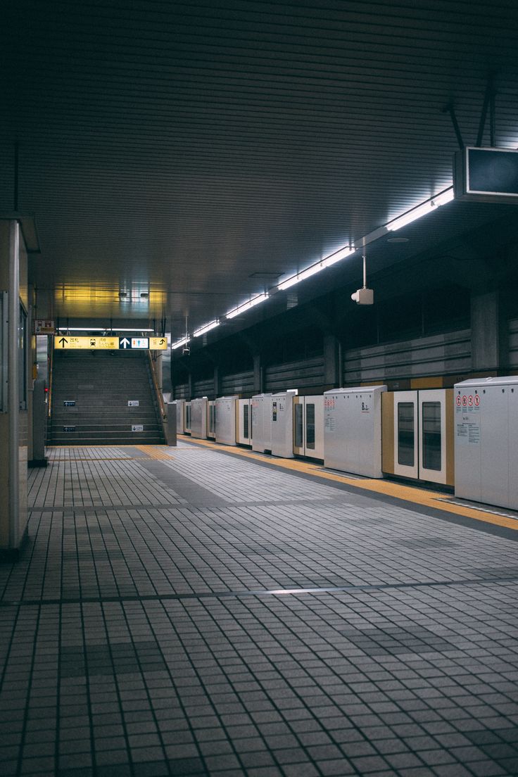 an empty subway station at night with lights on