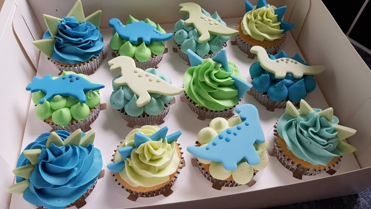 cupcakes decorated with blue and green frosting in a box