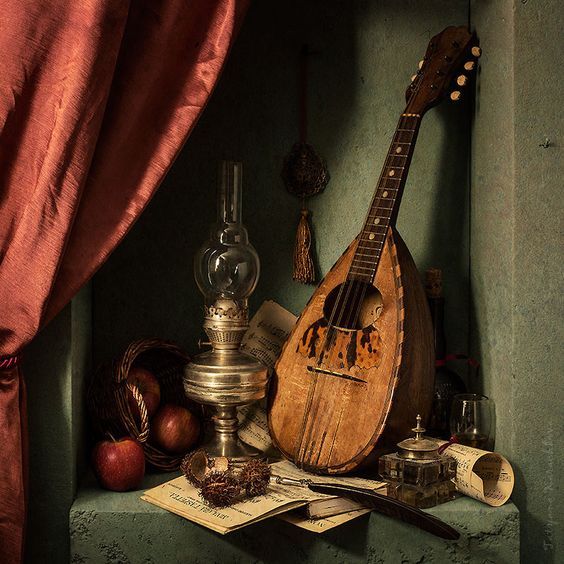 an old musical instrument sitting on top of a table next to a curtain and other items