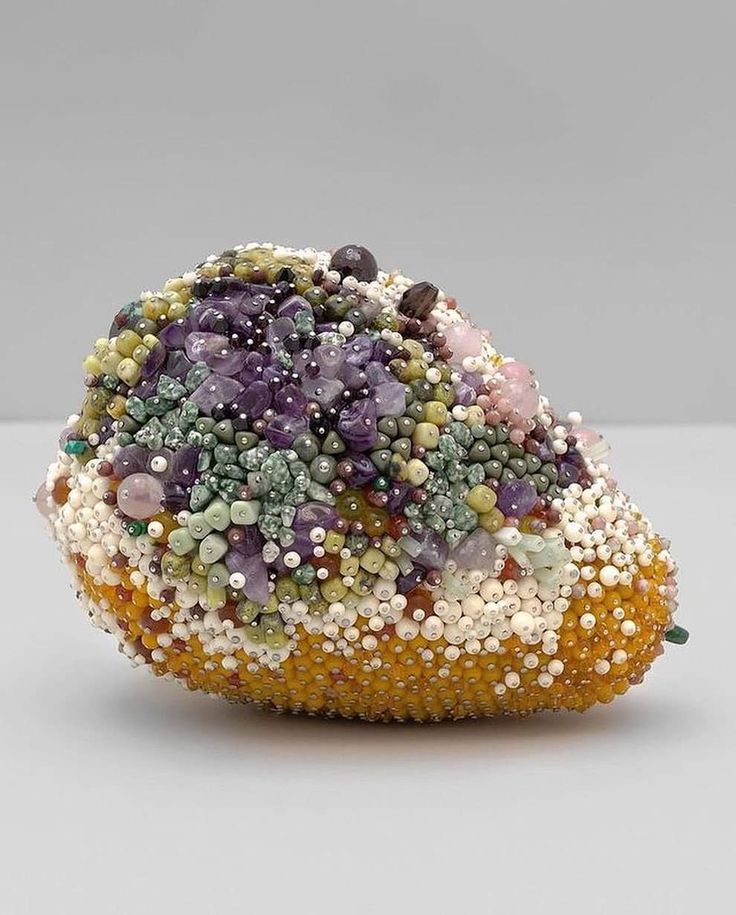 a rock covered in lots of different types of beads and stones on top of each other