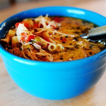 a blue bowl filled with soup on top of a wooden table