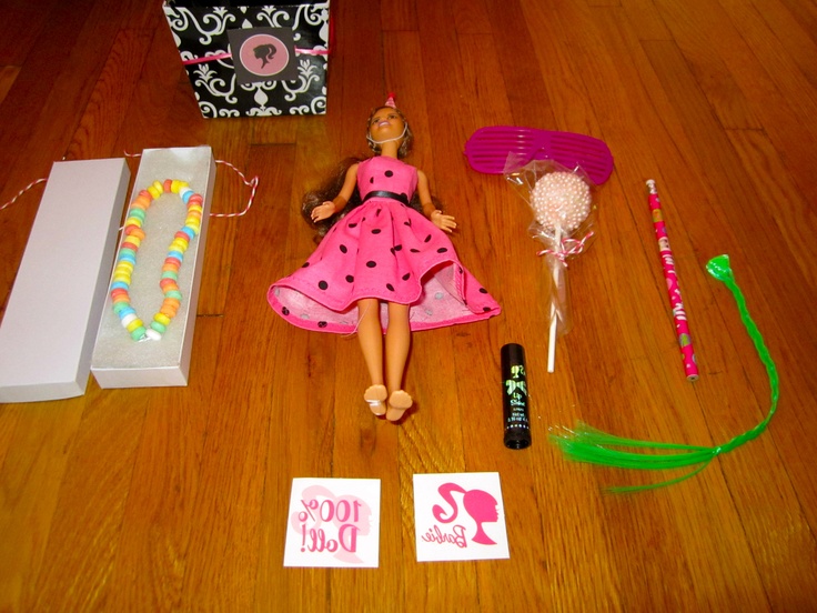 a barbie doll is laying on the floor next to her birthday party favors and decorations