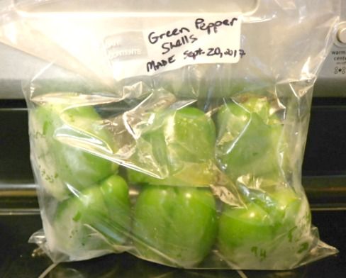 green peppers wrapped in plastic sitting on top of an oven