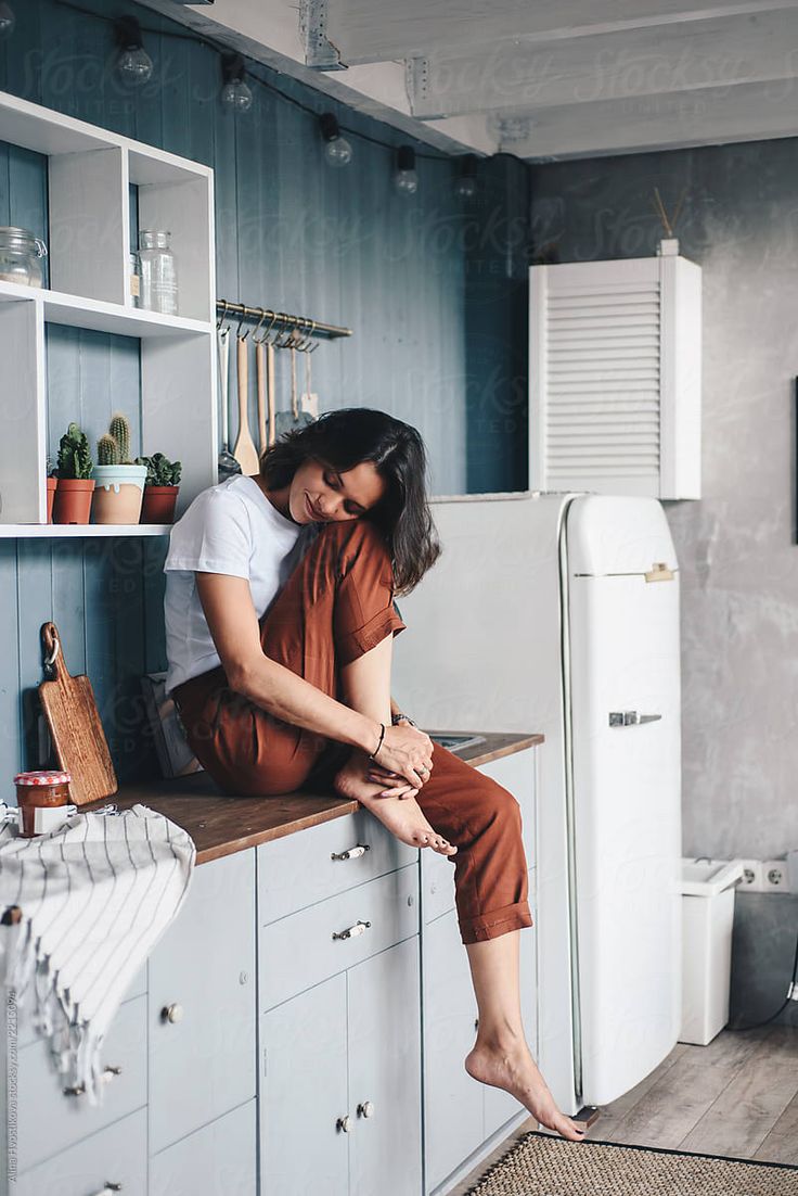 two people sitting on the counter in a kitchen