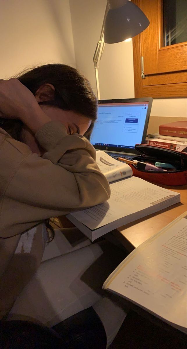 a woman sitting at a desk with her head in her hands