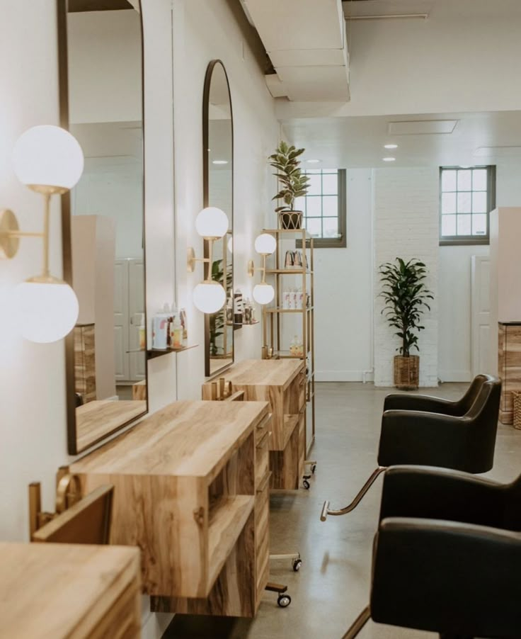 a hair salon with chairs, mirrors and lights on the wall in front of it