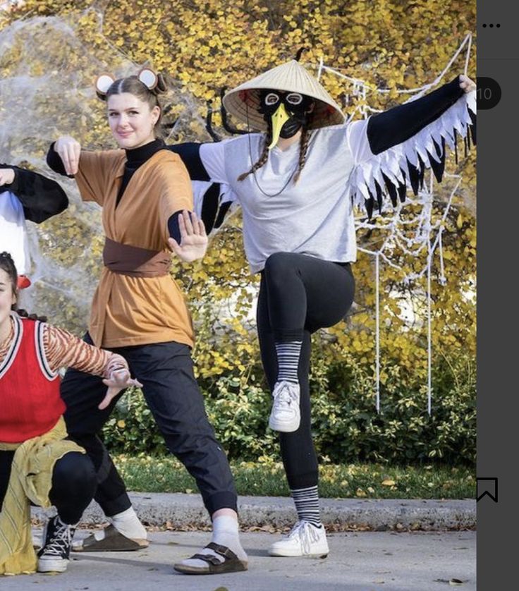 four people dressed up in costumes posing for the camera with their arms spread wide open