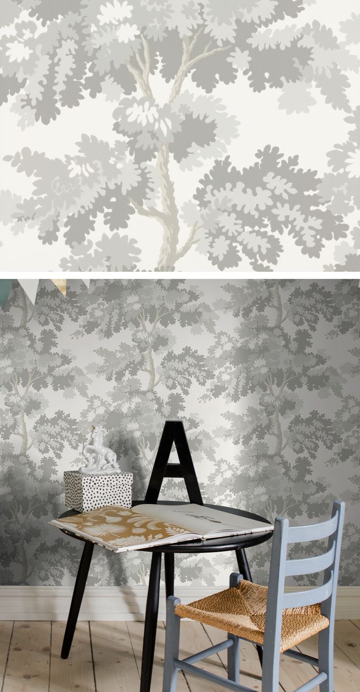 a table and chair in front of a wallpapered background with trees on it