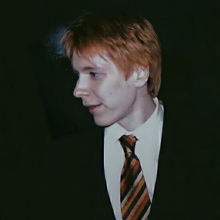 a young man in a suit and tie looking to his left with an intense look on his face