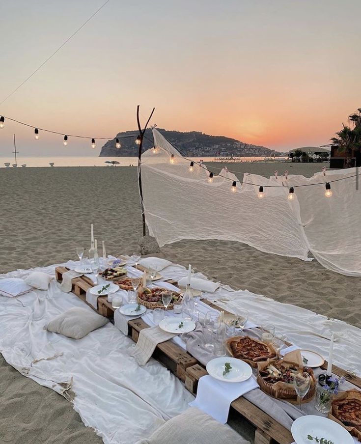 a table set up on the beach with food