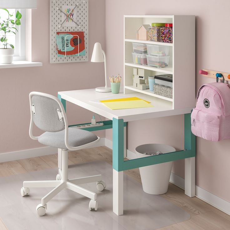 a child's desk and chair in a room with pink walls