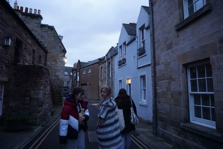 two women walking down an alley way in the evening